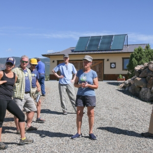 Solar Ambassador Elaine Brett (middle with cap) opens up her house to a “Solar Home Tour” as part of a Solarize educational event. The Brett’s 3.36 kW grid-tied PV system meets all their electrical needs. Being grid-tied allows the Bretts to take advantage of DMEA’s generous net-metering policy, which credits customers for the excess energy their systems produce. Picture shows the solar hot water system on their garage. The solar photovoltaic system is roof mounted on the adjoining house.